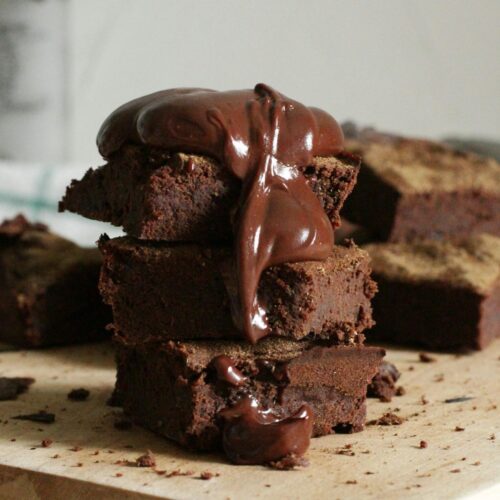 Close-Up Photo Of Stacked Brownies On Chopping Board