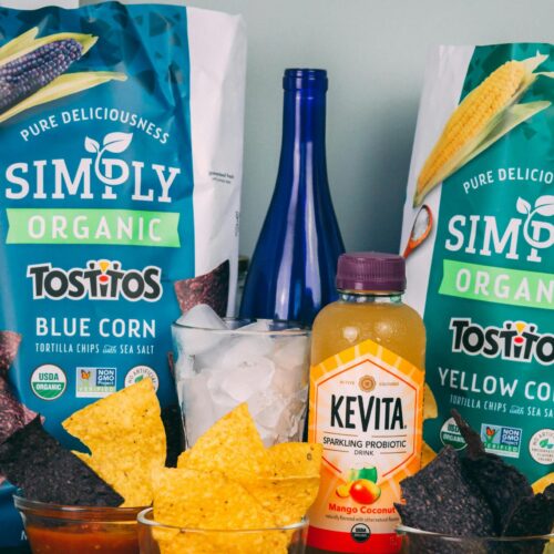 A colorful assortment of organic snacks including Tostitos chips and Kevita drink.