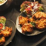 A flavorful assortment of Indian cuisine with various dishes on a serving tray, highlighting vibrant spices and textures.