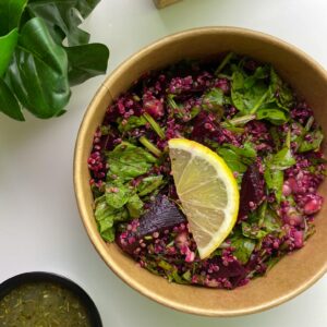 Vibrant beetroot salad with fresh greens and a lemon slice, perfect for a healthy meal.